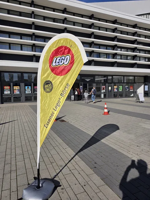 The Essener Lego-Börse beach flag with the LEGO logo, standing on the forecourt in front of the entrance to the Grugahalle